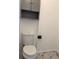 Updated toilet with gray upper cabinets at 2421 Queenswood Cir, Kissimmee, FL 34743