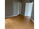Bedroom featuring wood-look floors, neutral paint, and two white doors at 2525 Maitland Crossing Way # 202, Orlando, FL 32810