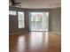 Bright living room with water views from the balcony through sliding glass doors and two large windows at 2525 Maitland Crossing Way # 202, Orlando, FL 32810
