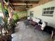 Comfortable covered back porch with lounge furniture, tile floors, plants, and natural wood ceiling at 2648 Amsden Rd, Winter Park, FL 32792