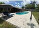 Backyard features an in-ground pool, patio, privacy fence, and blue lounge chairs with umbrella at 2648 Amsden Rd, Winter Park, FL 32792