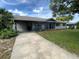 View of a well-kept home with a long driveway that leads to the street and a covered carport at 2648 Amsden Rd, Winter Park, FL 32792