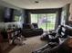 The living room has a large window with a view of the front yard and comfortable seating at 2648 Amsden Rd, Winter Park, FL 32792