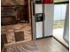Outdoor kitchen with a stainless steel refrigerator, brick accents, and an exterior door at 2648 Amsden Rd, Winter Park, FL 32792