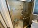 Tiled shower with glass door, built-in niche, and convenient seating at 2648 Amsden Rd, Winter Park, FL 32792