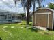 Backyard view featuring a pool with screened-in enclosure and storage shed at 2693 Maxwell W Ct, Kissimmee, FL 34743