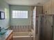 Bathroom featuring a vanity sink, glass block window, and separate glass enclosed shower at 2693 Maxwell W Ct, Kissimmee, FL 34743