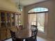 Dining room features a wood table set, china cabinet, and large window at 2693 Maxwell W Ct, Kissimmee, FL 34743