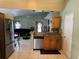 Open concept kitchen featuring stainless steel appliances, wooden cabinetry, tile backsplash, and view to the living room at 2693 Maxwell W Ct, Kissimmee, FL 34743