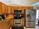 The eat-in kitchen features stainless appliances, granite countertops, wooden cabinetry, and a decorative tile backsplash at 2693 Maxwell W Ct, Kissimmee, FL 34743