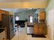 Open concept kitchen featuring stainless steel appliances, wooden cabinetry, tile backsplash, and view to the living room at 2693 Maxwell W Ct, Kissimmee, FL 34743