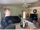The cozy living room features a ceiling fan, neutral paint colors, and a comfortable seating arrangement at 2693 Maxwell W Ct, Kissimmee, FL 34743