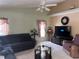 The cozy living room features a ceiling fan, neutral paint colors, and a comfortable seating arrangement at 2693 Maxwell W Ct, Kissimmee, FL 34743