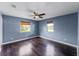 Bedroom featuring hardwood floors, two windows with blinds, and neutral wall color, creating a calming space at 2915 Dean Ridge Rd, Orlando, FL 32825