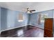 Bedroom with two windows, ceiling fan, dark wood floors, and neutral color scheme at 2915 Dean Ridge Rd, Orlando, FL 32825