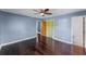 Bright bedroom features blue walls, dark wood floors, ceiling fan, and access to ensuite bathroom at 2915 Dean Ridge Rd, Orlando, FL 32825