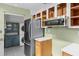 Close-up of the kitchen's modern stainless steel appliances, custom cabinets, and unique patterned flooring at 2915 Dean Ridge Rd, Orlando, FL 32825