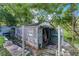 Exterior view of the storage shed, featuring a weathered exterior with an open door, surrounded by greenery at 2915 Dean Ridge Rd, Orlando, FL 32825