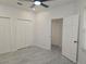 A spacious bedroom with tile flooring, white trim, ample closet space, and a modern ceiling fan at 3030 Clubview Dr # Ge, Orlando, FL 32822
