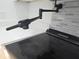 Close-up of a pot filler and flat top stainless steel electric range with gray backsplash at 3030 Clubview Dr # Ge, Orlando, FL 32822