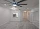 Bright and airy living room showcasing gray tile flooring, kitchen view, and a modern ceiling fan at 3030 Clubview Dr # Ge, Orlando, FL 32822