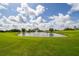 Scenic golf course view with a pond, surrounded by lush green grass and a clear blue sky with fluffy clouds at 3030 Clubview Dr # Ge, Orlando, FL 32822