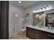 Stylish bathroom featuring a double vanity, decorative mirror, and elegant fixtures at 3176 Feltrim Pl # 302, Kissimmee, FL 34747