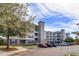 Apartment building featuring a parking lot and view of blue sky at 3176 Feltrim Pl # 302, Kissimmee, FL 34747
