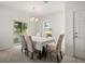 Bright dining room with stylish chandelier, slider to backyard, and patterned chairs and a large window at 3537 Seneca Club Loop # B, Orlando, FL 32808