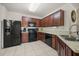 Well-equipped kitchen featuring black appliances, wood cabinets, and tile flooring for easy maintenance at 3537 Seneca Club Loop # B, Orlando, FL 32808