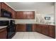 Functional kitchen with dark wood cabinetry, black appliances, and tile floors for practical living at 3537 Seneca Club Loop # B, Orlando, FL 32808