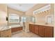 Well-lit bathroom with a soaking tub, tiled floors, and double sink vanity at 3954 Old Dunn Rd, Apopka, FL 32712