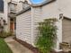 Side view of home with well-maintained landscaping, neutral paint, and pathway to the front door at 3966 Villas Green, Longwood, FL 32779