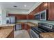This kitchen features stainless steel appliances, granite countertops, and rich wood cabinetry at 3966 Villas Green, Longwood, FL 32779