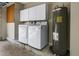 Well-equipped laundry area featuring a washer, dryer, water heater, and storage cabinets at 3966 Villas Green, Longwood, FL 32779