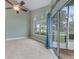 Neutral living room with tile flooring, tall ceilings, large windows, and a sliding glass door at 3966 Villas Green, Longwood, FL 32779