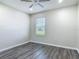 A bright bedroom featuring gray wood-look floors, a ceiling fan, and a window at 3975 Silverstream Ter, Sanford, FL 32771