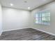 Bright bedroom with wood-look floors, neutral paint, and large window providing ample natural light at 3975 Silverstream Ter, Sanford, FL 32771