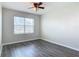 This bedroom features gray wood-look floors, a ceiling fan, and a bright window at 3975 Silverstream Ter, Sanford, FL 32771