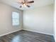 Bright bedroom with gray wood-look floors and natural light from the window at 3975 Silverstream Ter, Sanford, FL 32771