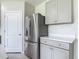 Modern kitchen details showcasing stainless steel refrigerator, gray cabinetry, and light countertops at 3975 Silverstream Ter, Sanford, FL 32771