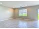 Open living room with tile flooring, a window with blinds, and ample natural light at 3975 Silverstream Ter, Sanford, FL 32771