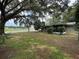 Expansive backyard with lush greenery, providing ample space for outdoor activities and relaxation, with a screened in porch at 401 Sunny Ct, Fruitland Park, FL 34731