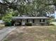 Charming single-story home featuring a covered carport, a welcoming front door, and a well-maintained lawn at 401 Sunny Ct, Fruitland Park, FL 34731