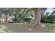Back exterior view with a screened in porch, showcasing lush greenery and mature trees at 401 Sunny Ct, Fruitland Park, FL 34731