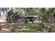 Back exterior of home with a screened in porch, and a well manicured yard at 401 Sunny Ct, Fruitland Park, FL 34731
