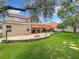 Expansive backyard featuring a patio, outdoor kitchen, lounge area, fire pit, and green lawn at 4334 Tolkien St, Orlando, FL 32828