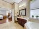 Bright bathroom with double vanity, marble countertops, and a separate tub with a view to the bedroom at 4334 Tolkien St, Orlando, FL 32828