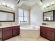 Luxurious bathroom with a soaking tub, -and- dark wood vanities, and decorative tile work at 4334 Tolkien St, Orlando, FL 32828
