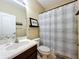 Bathroom featuring tile floors, a white sink, a toilet, and a shower and tub with a curtain at 4334 Tolkien St, Orlando, FL 32828